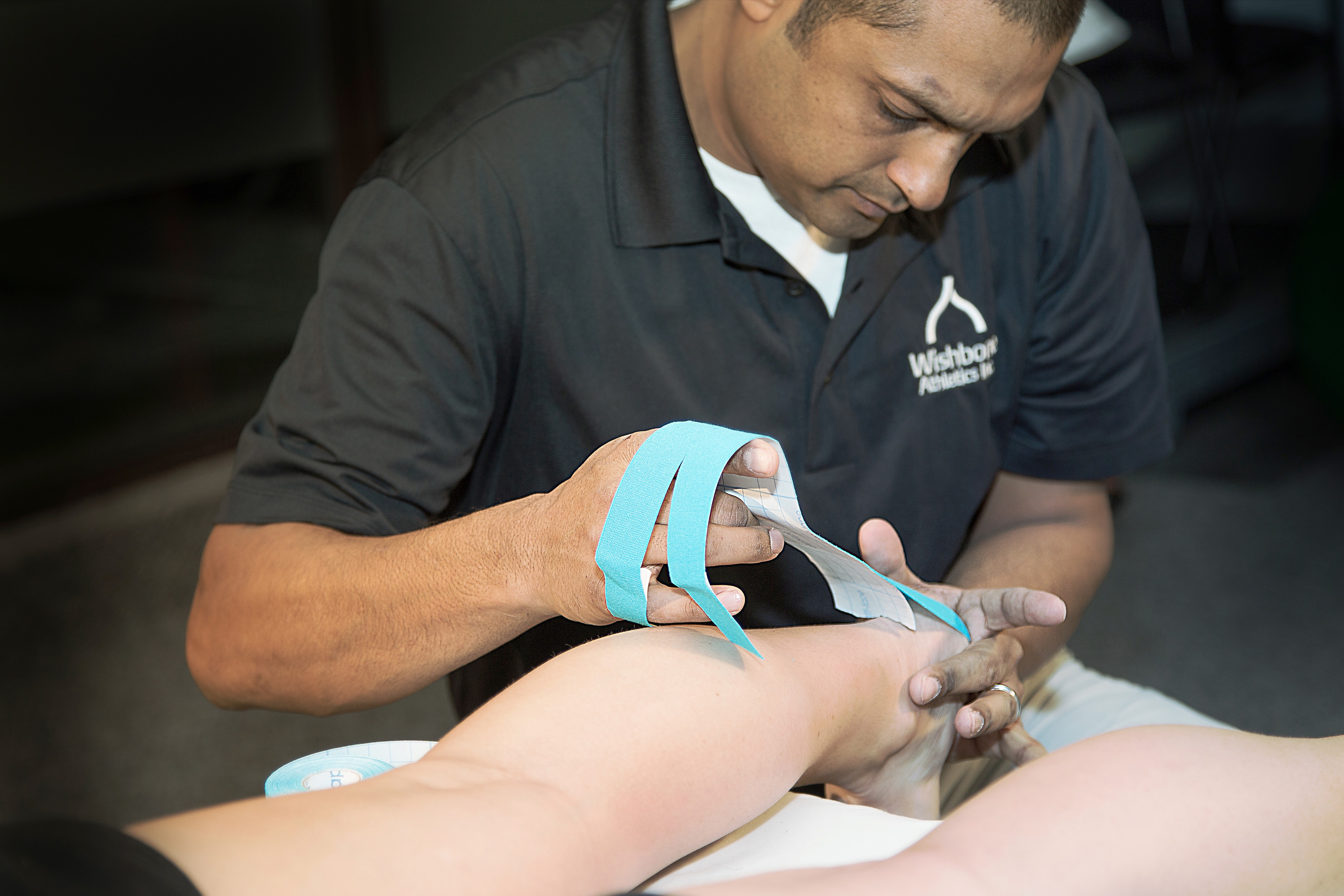 Athletic Therapist taping an injury